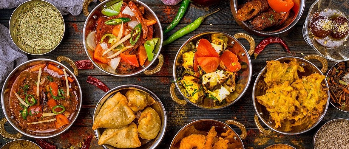 A table full of a wide variety of traditional Indian dishes