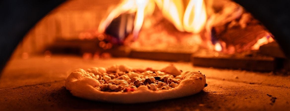 Pizza cooking in the wood fire oven at Padrinos Pizzeria in Haringey