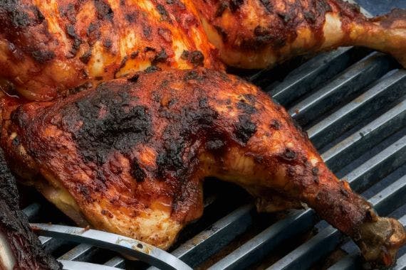 Delicious peri chicken cooking on a grill