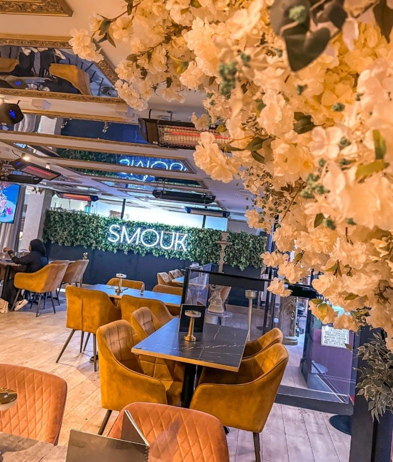 Inside SMOUK Restaurant with a few clients and LED lights on the logo