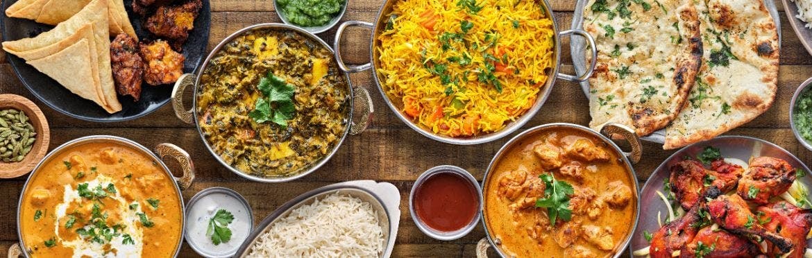 A selection of Indian takeaway dishes laid out on a table