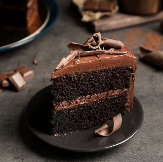 Chocolate fudge cake on a small plate from Perico Dessert Box (Tipton)