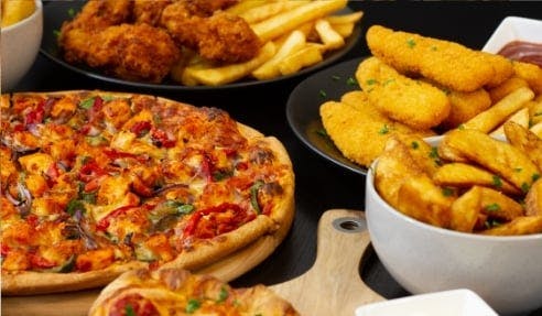 A variety of food items including pizza, fries, chicken strips, and potato wedges.